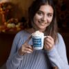 mockup of a woman enjoying a pumpkin spice latte in her 11 oz coffee mug 29140 11oz Personalized Season's Greeting Blue Deers Christmas Mug